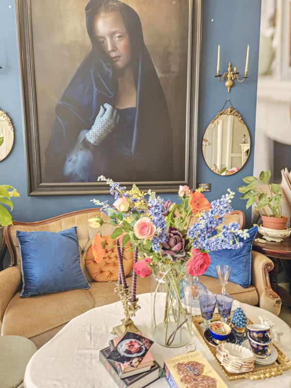 Petrolblauwe salon met schilderij en vintage bank